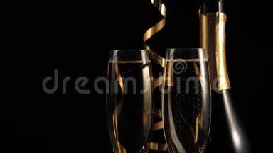 好香槟酒。 两杯金香槟酒和一瓶香槟酒，木桌上放着金色的丝带
